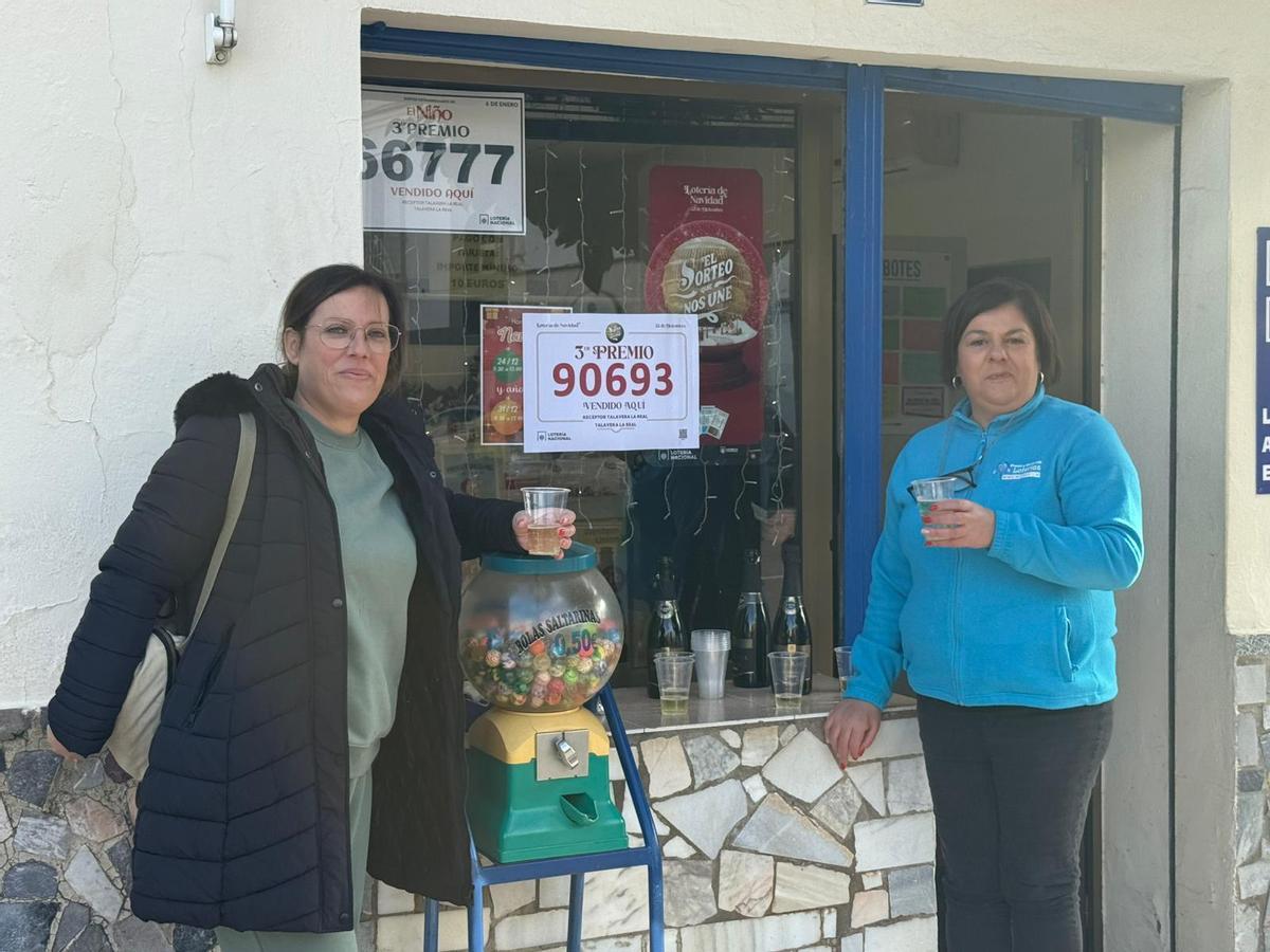 Pepi Rey, a la izquierda, celebra el tercer premio repartido en su establecimiento con una vecina de Talavera la Real (Badajoz).