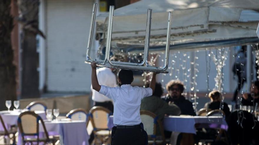 Un camarero monta una mesa en la terraza de un restaurante del centro de Barcelona