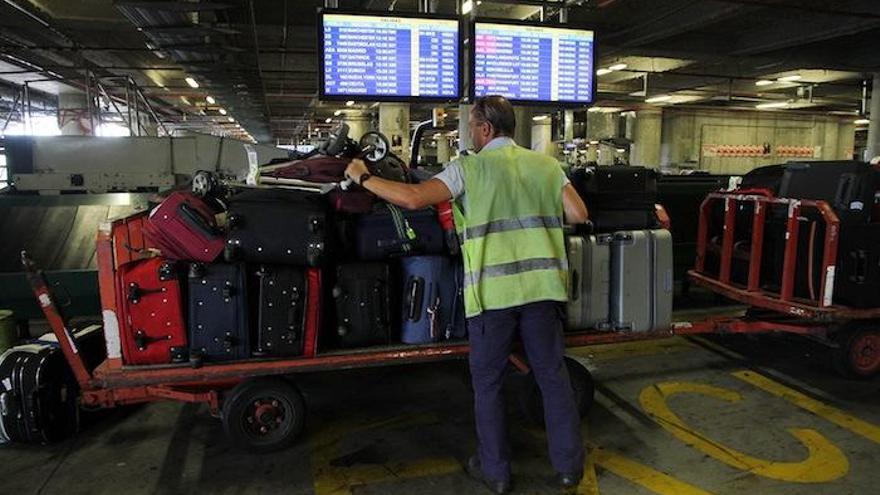 Un operario se ocupa del movimiento de los equipajes en las tripas del aeropuerto.