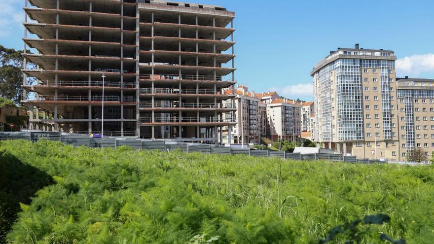 La parcela cedida a la Xunta, en primer término y el esqueleto, al fondo. | Germán Barreiro/ Roller Agencia