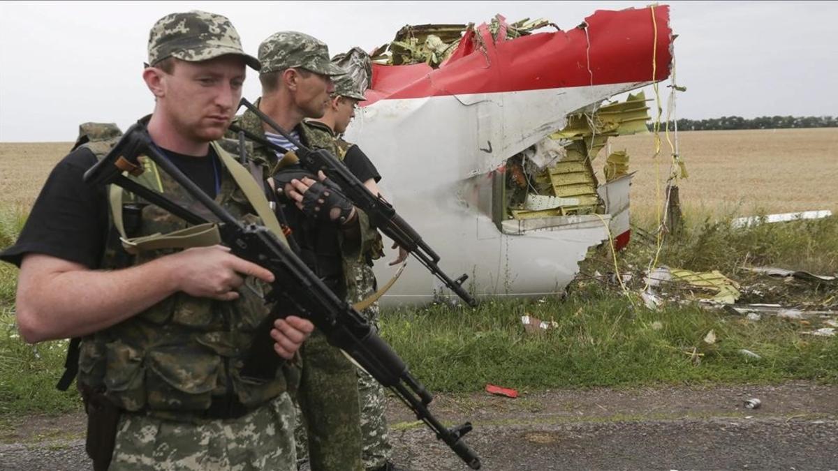 Rebeldes prorrusos armados, al lado del fuselaje del avión derribado, en julio de 2014.