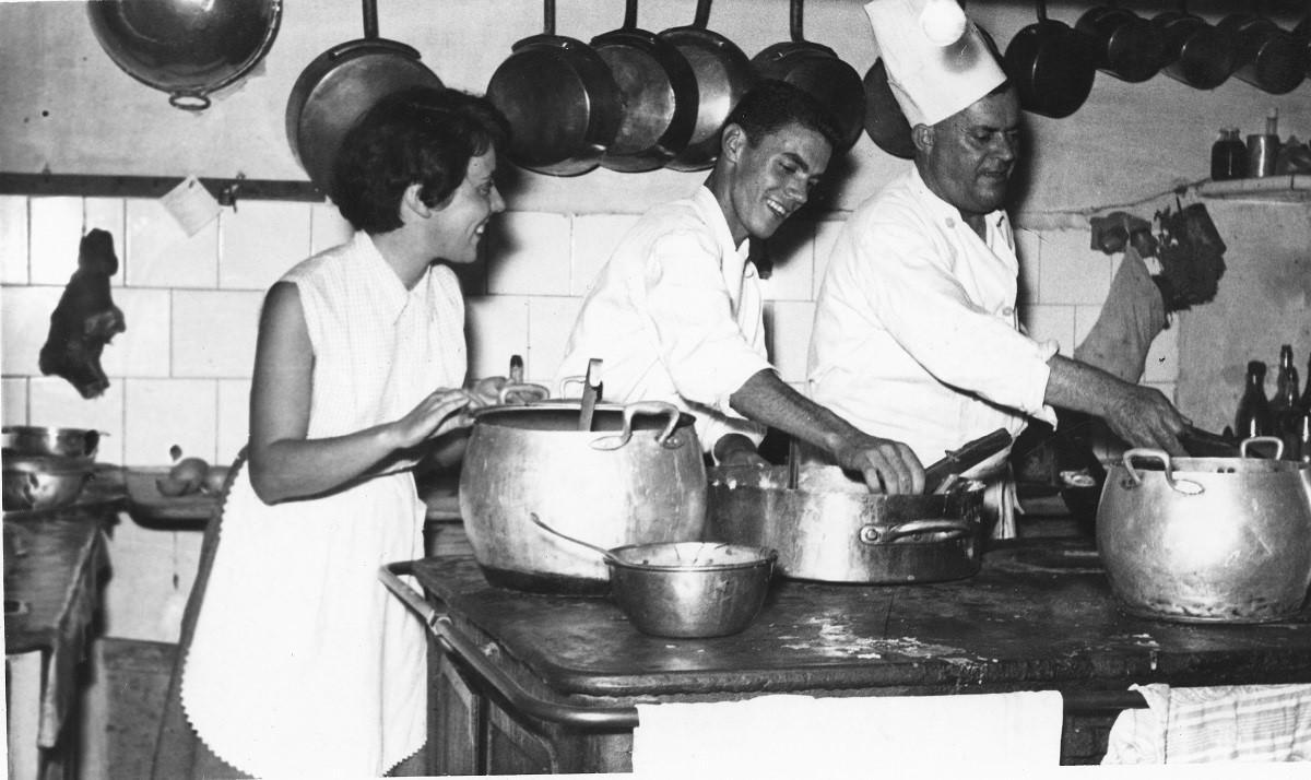 La família Gotanegra feinejant en els fogons amb l’avi Norat portant el gorro de cuiner