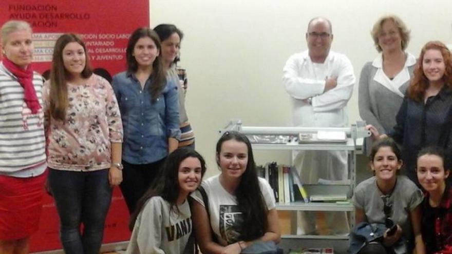 Voluntarios con el carro de los libros y un sanitario.