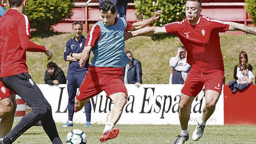 Álex López golpea el balón ante la presión de Juan Rodríguez.