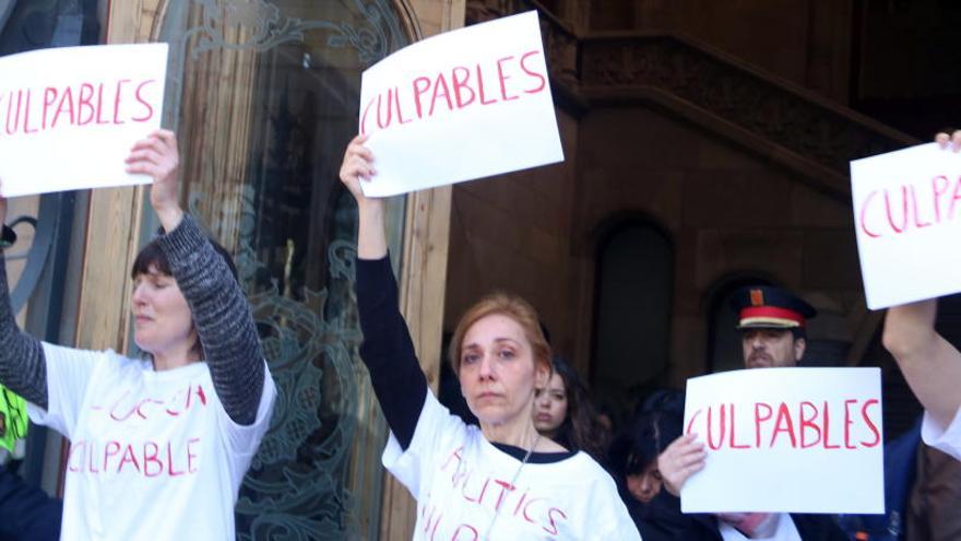 Diverses dones amb cartells de &#039;culpables&#039; sortint de l&#039;Audiència de Barcelona