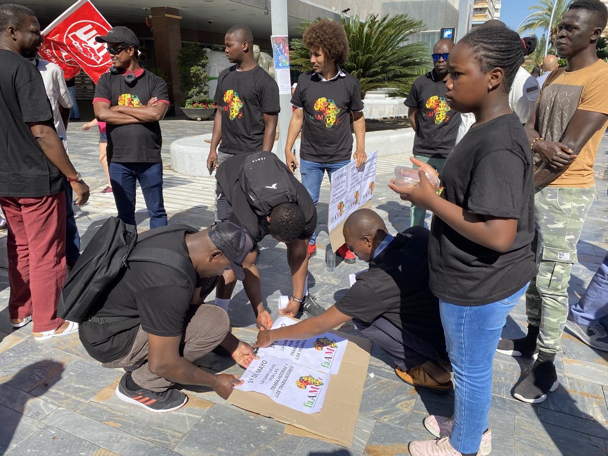 Miembros de la Federación de Asociaciones Africanas de Murcia realizan pancartas antes de que partiese la marcha.