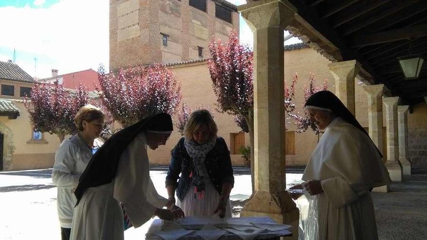 Dos religiosas del convento entregan a Ramírez, en el centro, la mantelería del sorteo.