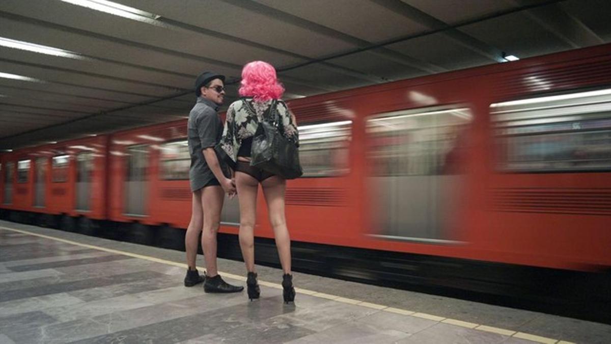 Dos participantes en el evento 'Sin pantalones en el metro', en una estación del suburbano mexicano, el 12 de enero del 2014.