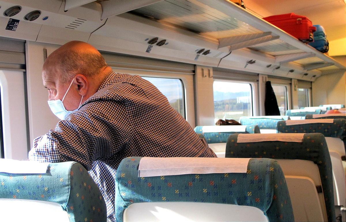 Un viajero del Euromed mira por la ventana en el momento que el tren pasa junto a Marina d'Or (ciudad de vacaciones)