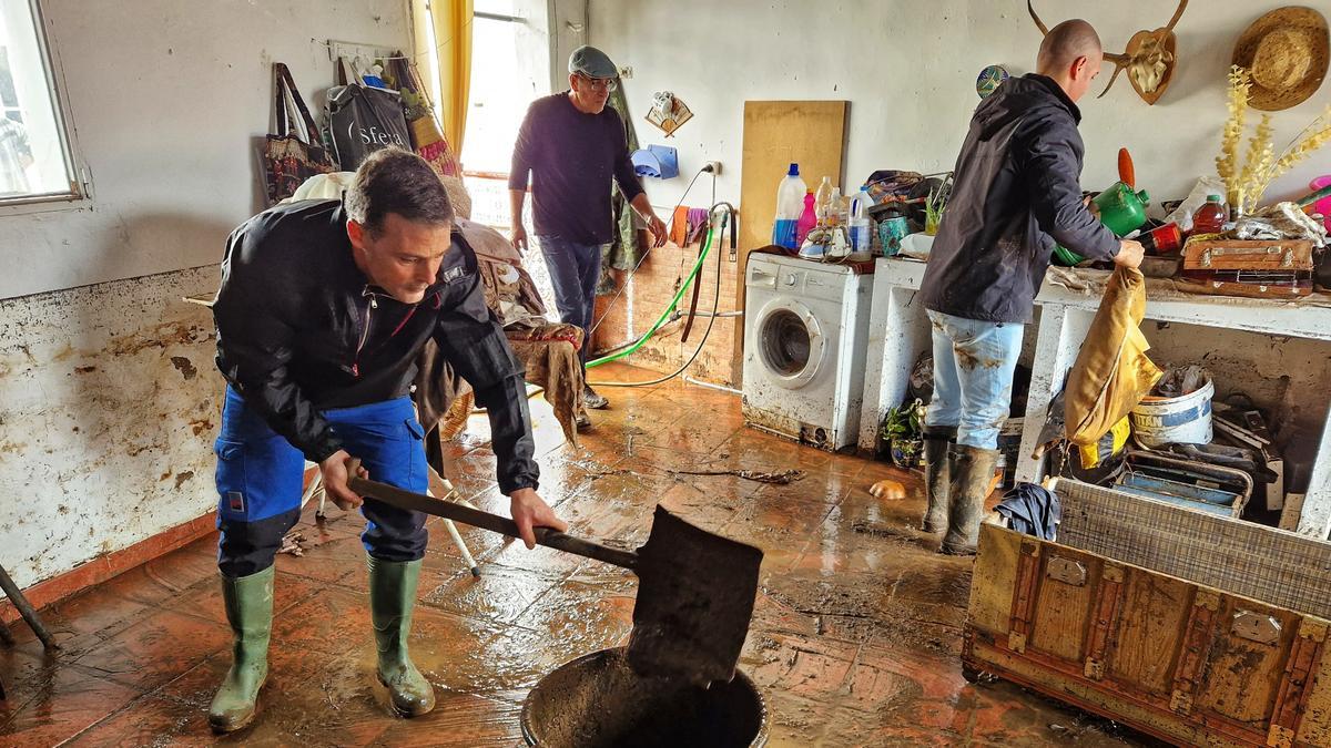 Vecinos de La Roca de la Sierra limpian una casa tras las inundaciones.