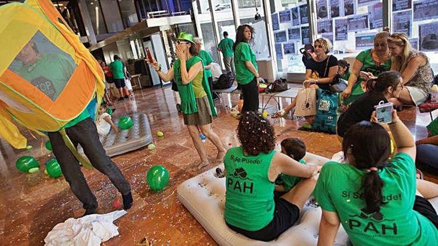 Activistes de l&#039;entitat fent una assentada al vestíbul de l&#039;ajuntament de Barcelona, aquest dijous.