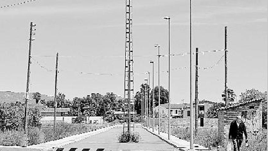 Una de las calles del Madrigal con una torre eléctrica en medio.