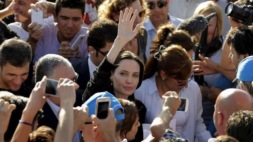 La actriz Angelina Jolie saluda, ayer, entre la multitud en su visita al campo de refugiados.