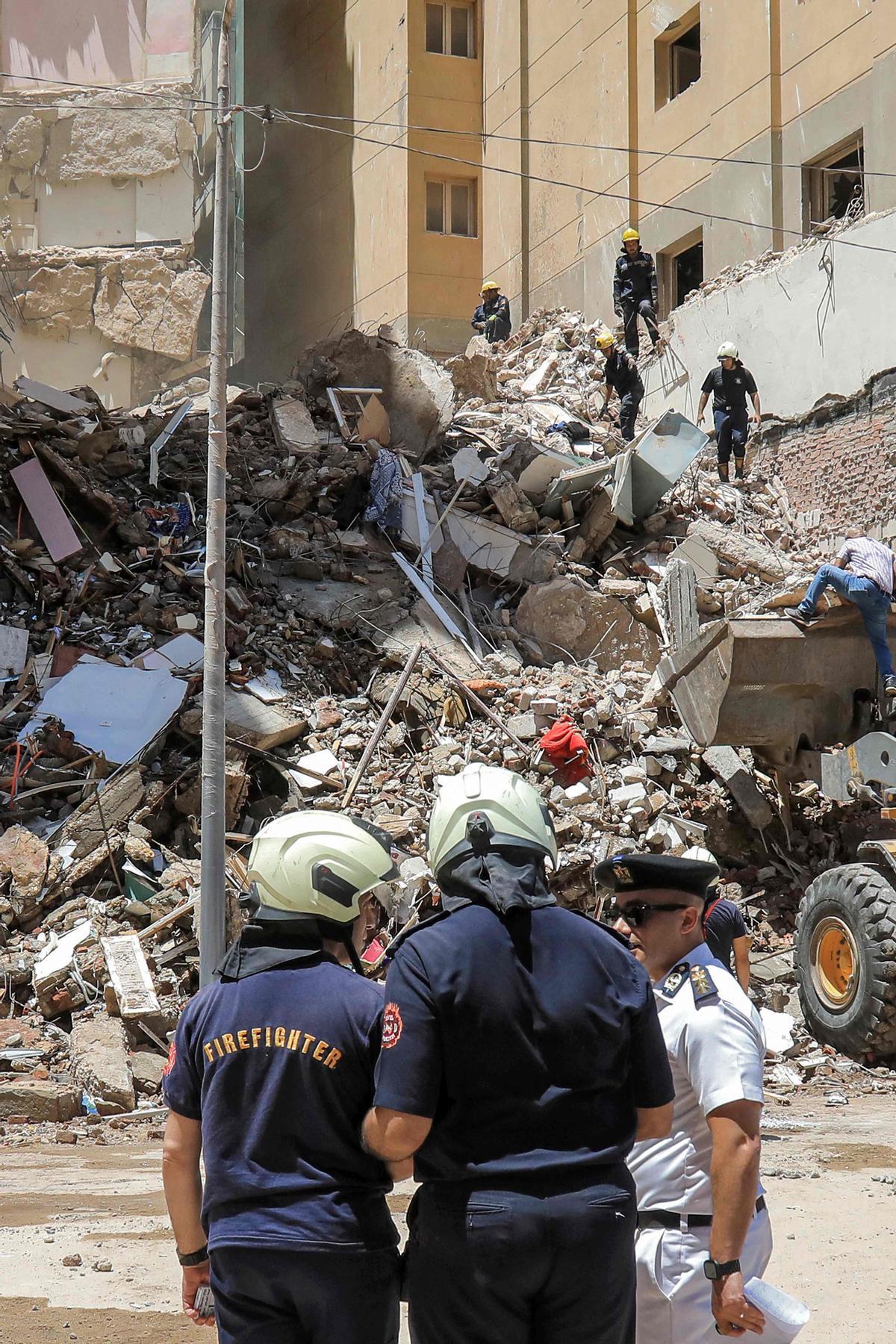 Los socorristas de defensa civil buscan entre los escombros en la escena de un edificio derrumbado de 13 pisos en el distrito de Sidi Bishr de la ciudad de Alejandría, en el norte de Egipto.