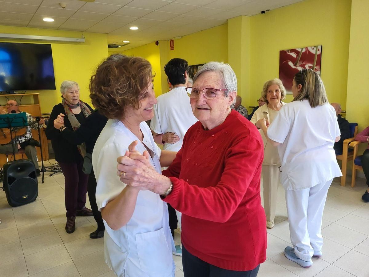 Varios trabajadores del centro de día Germans Folch i Traver bailan con las personas a las que cuidan.