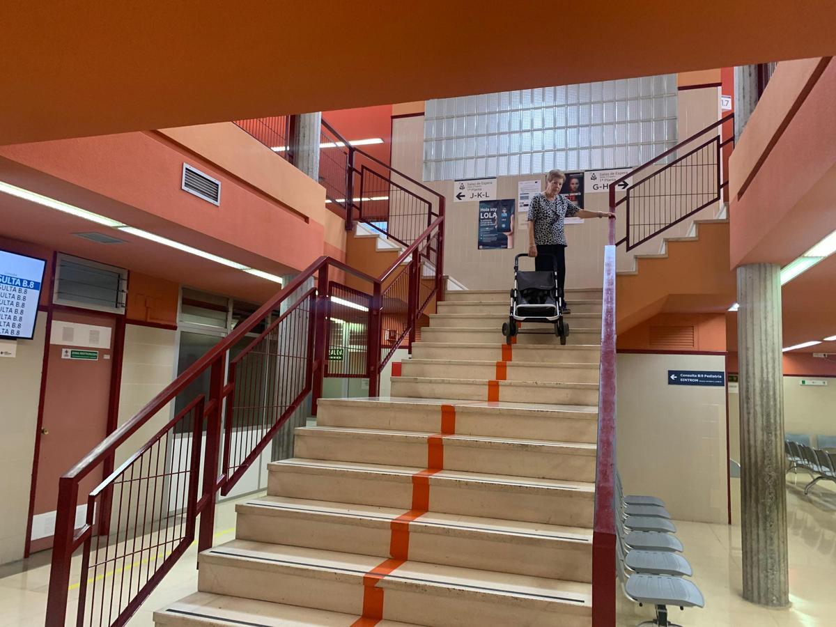 Una mujer baja por las escaleras del centro de salud al no funcionar el ascensor