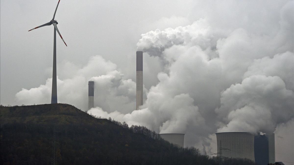 Un aerogenerador eólico delante de las torres de ventilación de la central térmica de Gelsenkirchen, en el estado alemán de Renania del Norte-Westfalia.