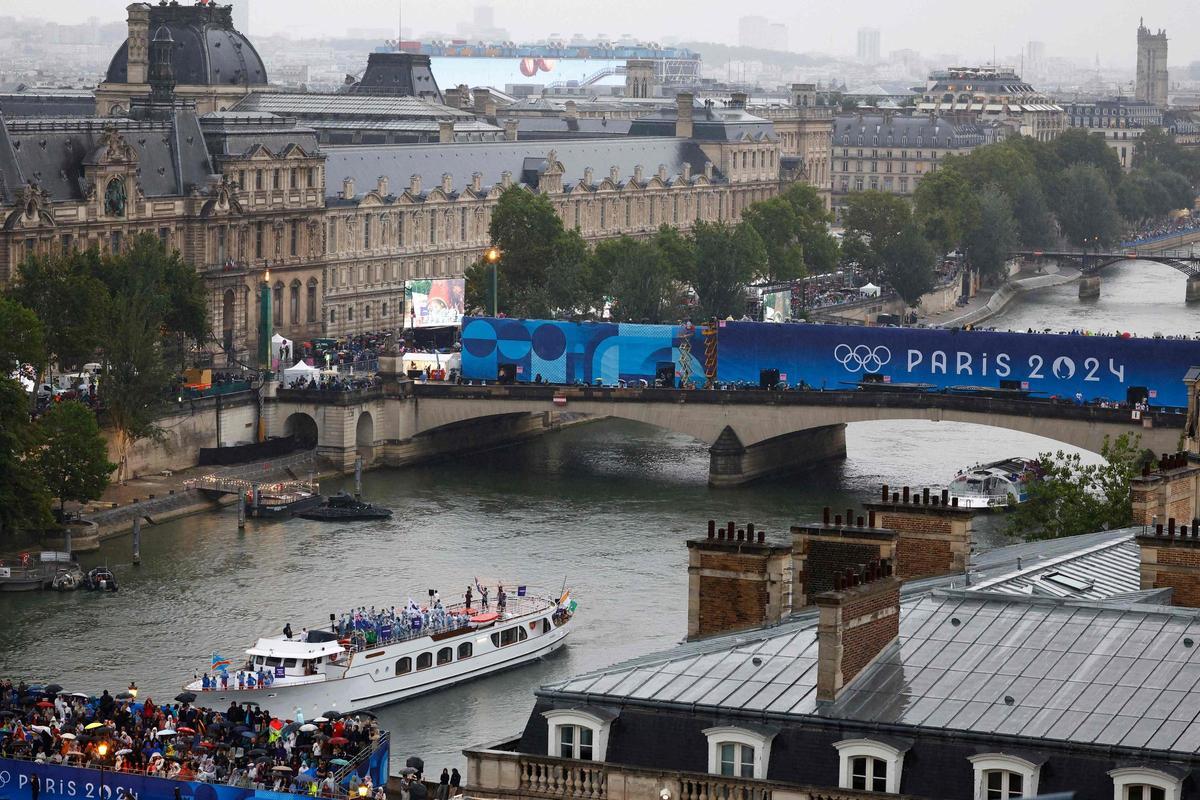 Los barcos desfilan por el Sena a su paso por el Museo del Louvre durante la ceremonia de apertura