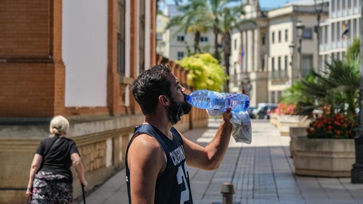 Un joven se refresca con una botella de agua en el centro de Badajoz.