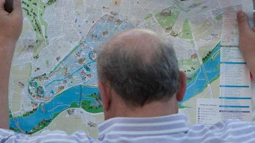 Un hombre ojea uno de los mapas turísticos editados de la ciudad.