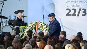 Un bombero y un agente de seguridad colocan un corona de flores en el aeropuerto de Zaventem, durante el homenaje a las víctimas de los ataques yihadistas, en Bruselas, el 22 de marzo.