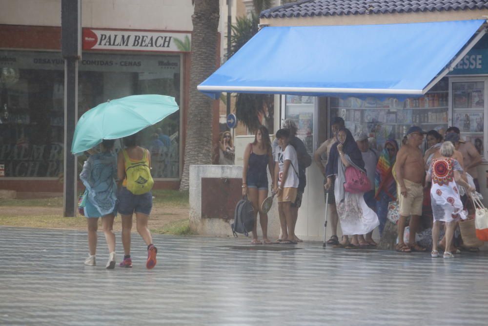 La lluvia sorprende a los bañistas en el Postiguet