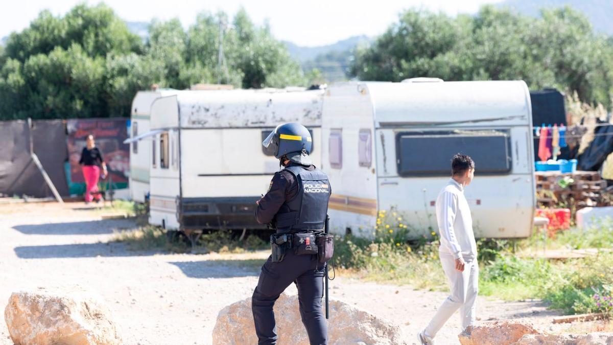 Un policía nacional frente a unas caravanas.