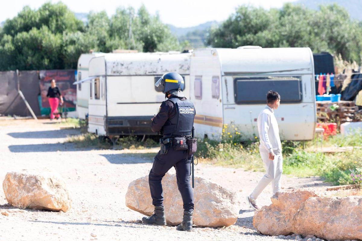 Un policía nacional frente a unas caravanas.