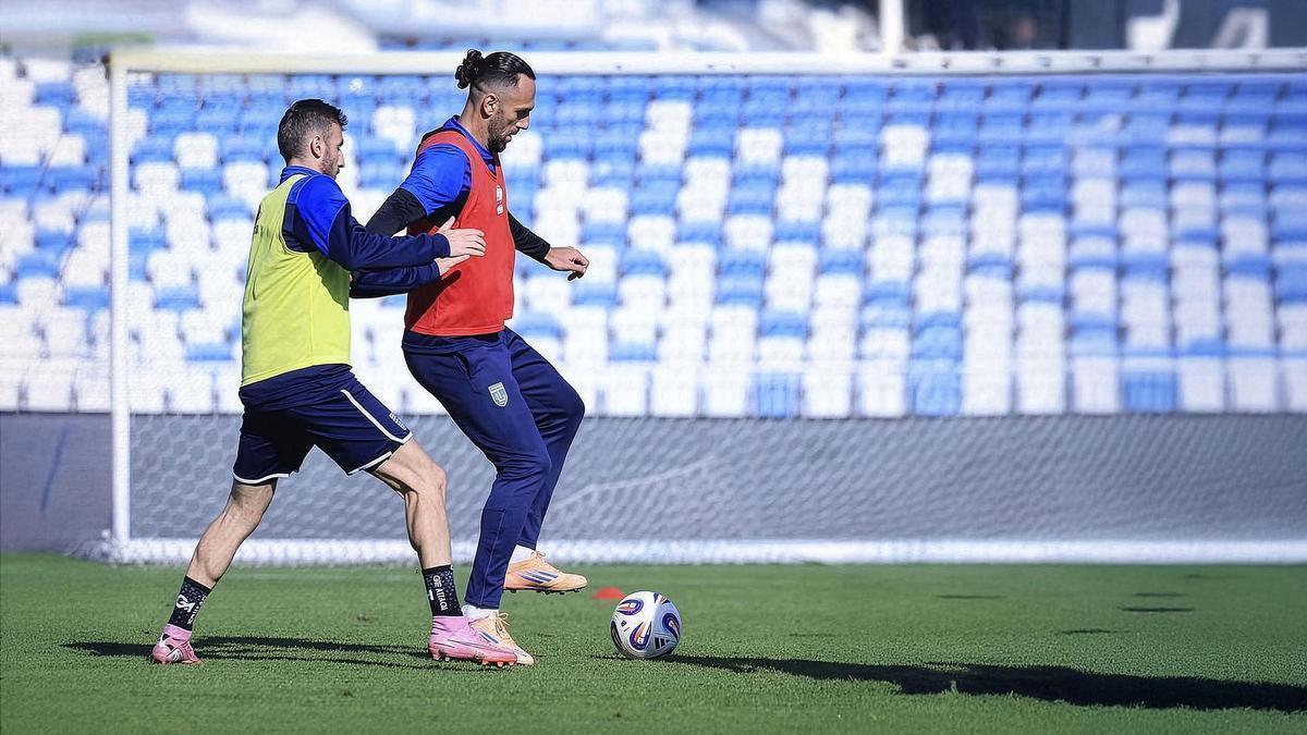 Muriqi protege el balón ante un compañero de selección.