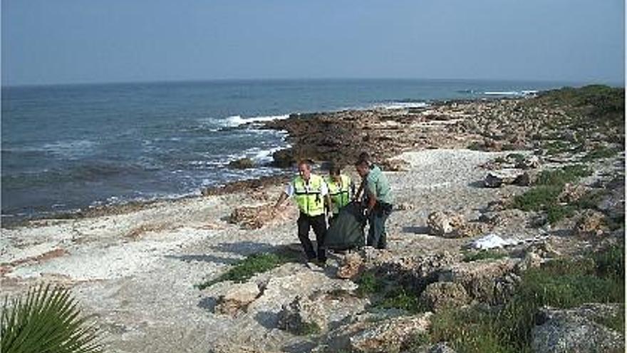 levantamiento. Efectivos de la Guardia Civil y dos operarios de la funeraria trasladan el cadáver de la playa de Peñíscola.