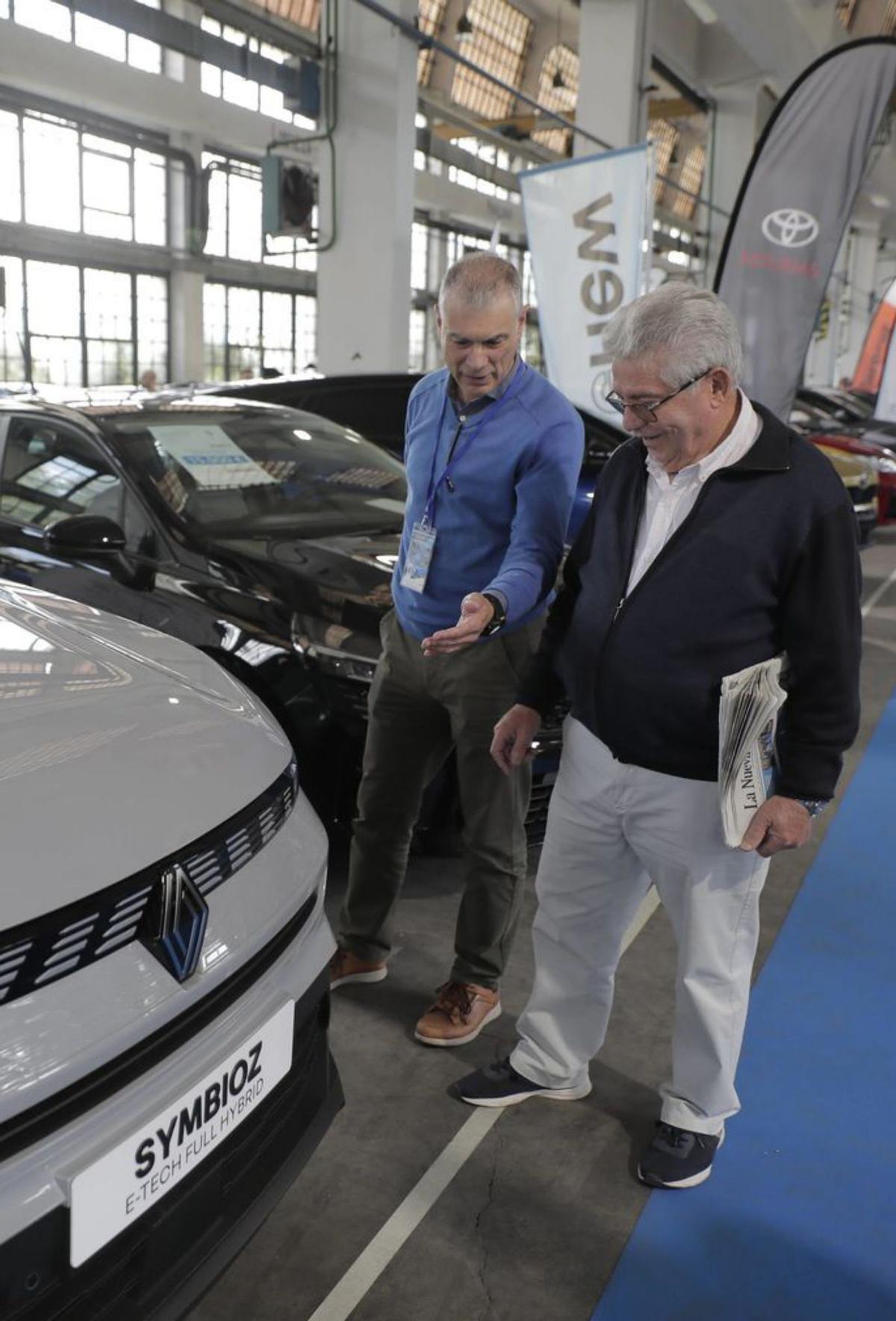 Celestino Pérez, a la izquierda, le enseña un coche a Avelino Menéndez. | MARIO CANTELI