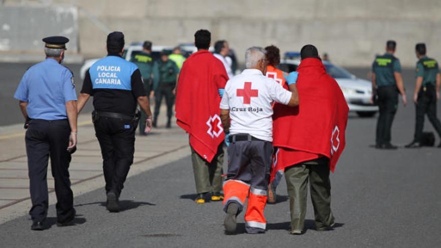 Los agentes y Cruz Roja, con inmigrantes llevados a Arinaga por un barco de Salvamento el pasado 29 de enero.