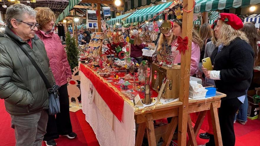 Público en el expositor de Impresiones Arva, ayer, en el mercadillo allandés.  | D. ÁLVAREZ