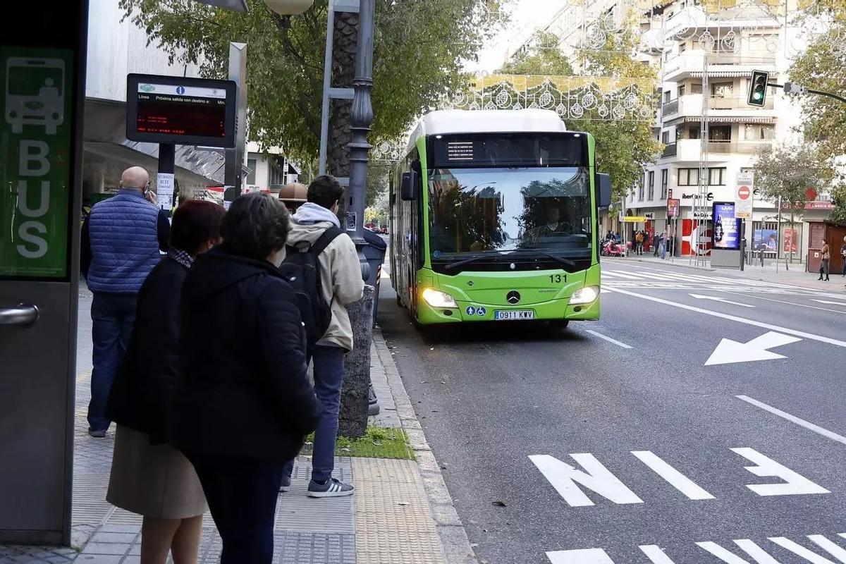 Varios pasajeros esperan a un autobús de Aucorsa en una parada.