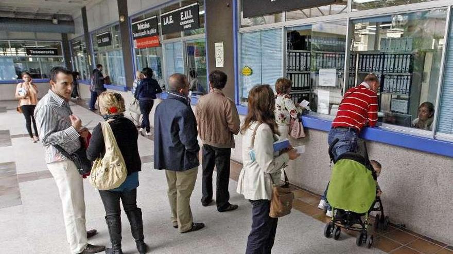 Ciudadanos realizando trámites en la lonja municipal. // M. G. Brea