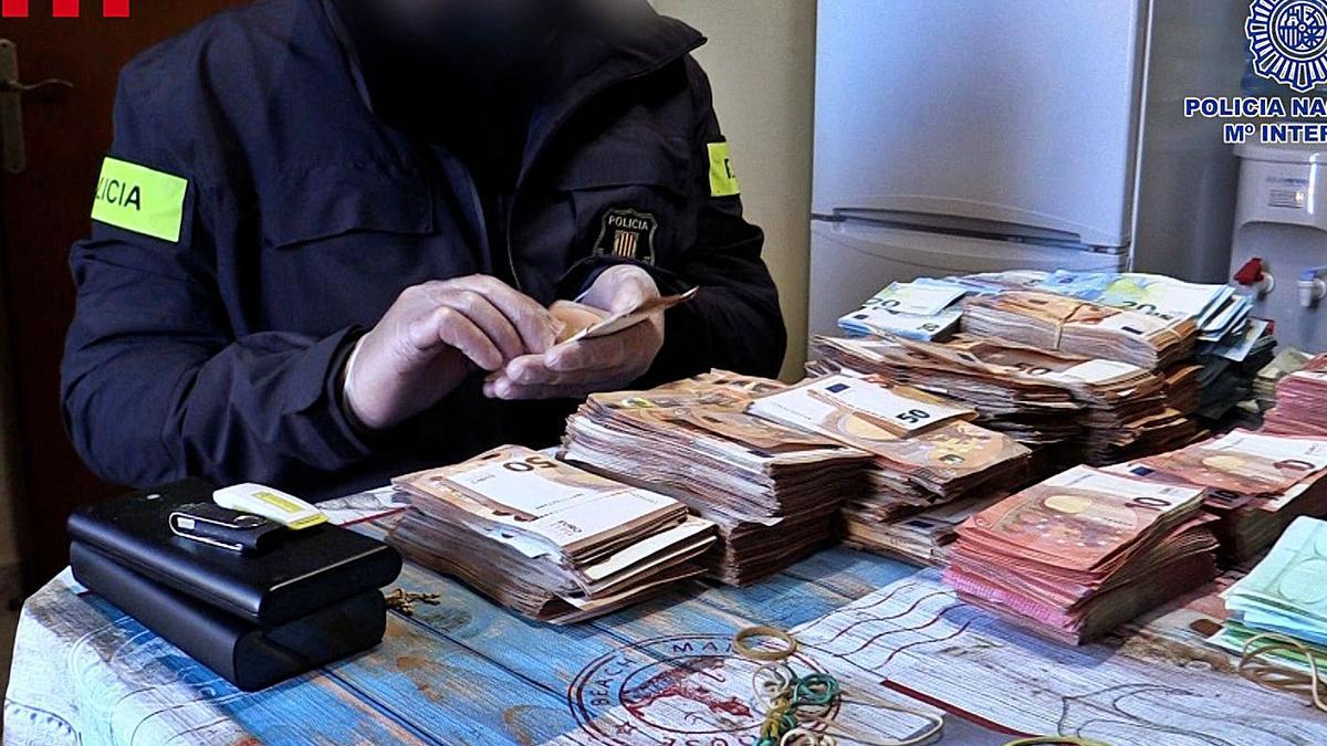 La policia amb diners localitzats durant els escorcolls en el marc del macrooperatiu. | MOSSOS D’ESQUADRA