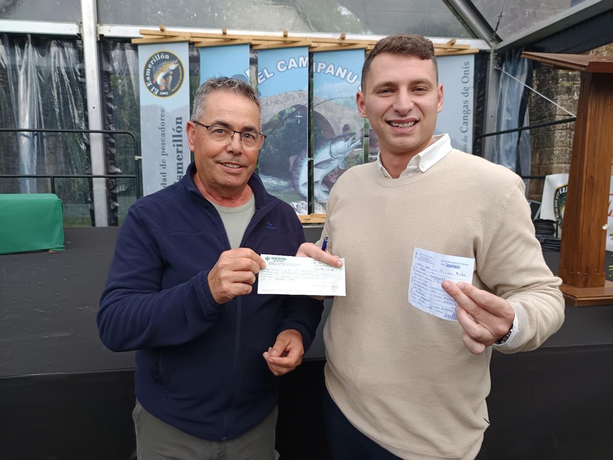 El momento en el que Adrián Mori, del Grupo El Campanu, entrega el talón por importe de 11.400 euros al agraciado pescador del campanu del Sella, José Murillo Mohedano, quién, a su vez, le da la guía del citado salmón al hostelero de Cangas de Onís.