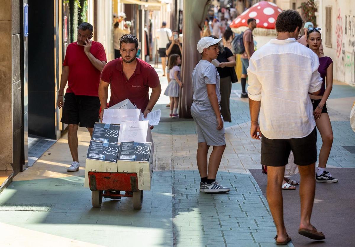 Álvaro Gil empuja el carro de reparto en una céntrica calle de Alicante, este miércoles.