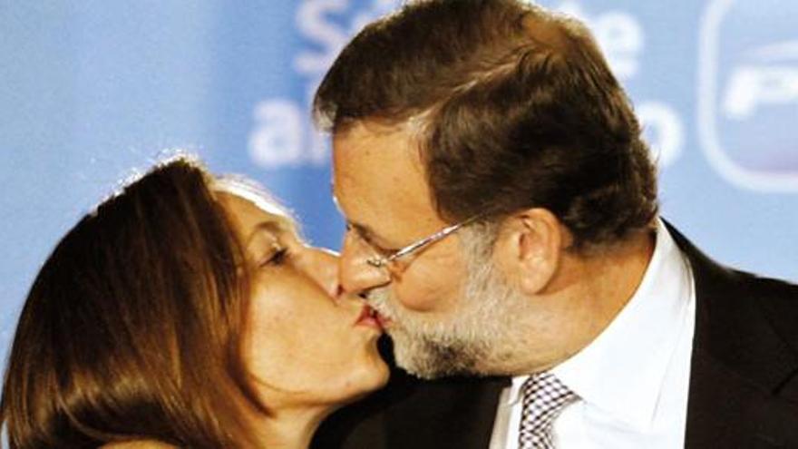 Mariano Rajoy besa a su mujer en su primera comparecencia en el balcón de la sede madrileña del PP en la calle Génova ante los militantes y simpatizantes de su partido.