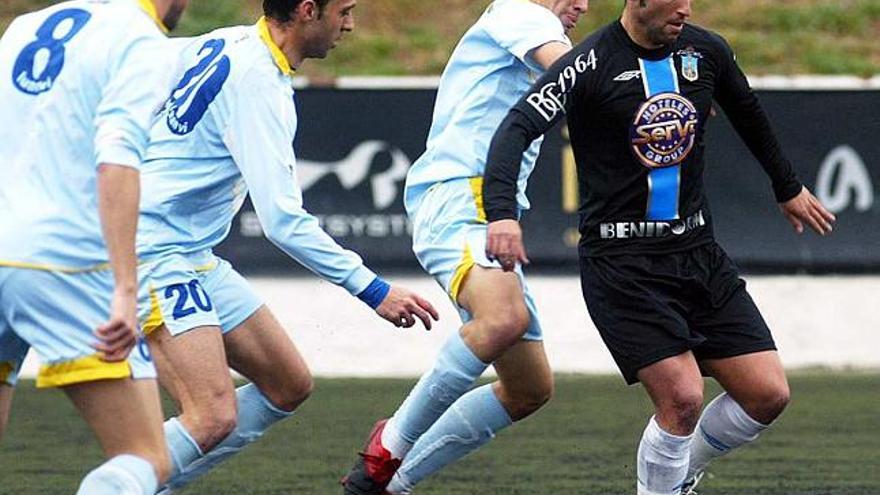 Luismi Loro protege el balón ante el acoso de varios jugadores del Badalona
