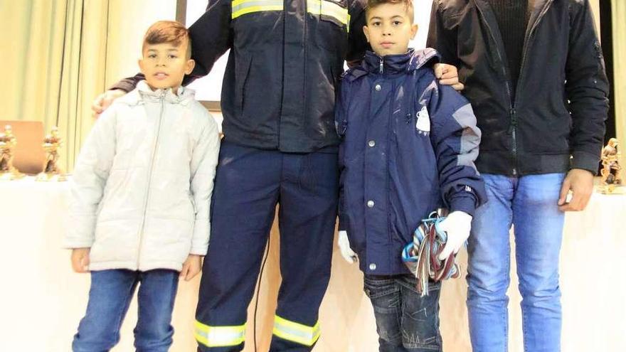 Atah Mohamad, junto a sus dos hijos y el bombero Javier Bodego.
