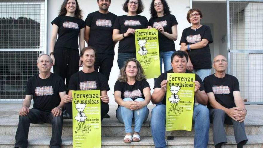 Miembros de la directiva de la asociación cultural A Fervenza de Ouzande con el cartel del festival.