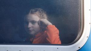 Una niña evacuada desde la ciudad de Odessa en Ucrania observa desde la ventana del tren en una parada en la estación de Lviv