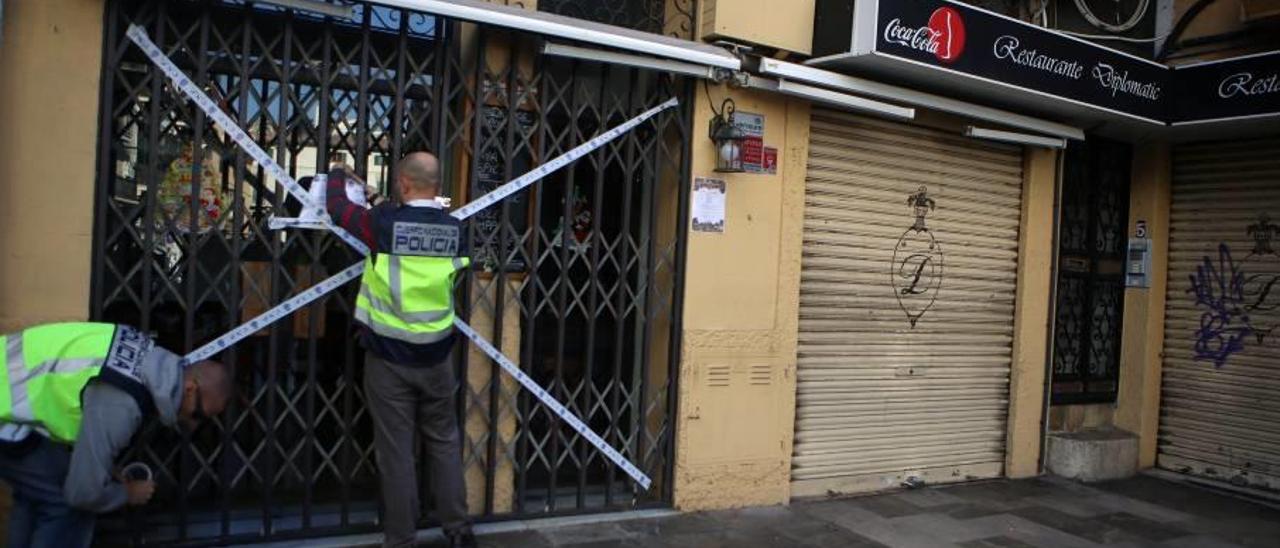 Dos policías precintan uno de los locales clausurados por orden judicial, el viernes en Palma.