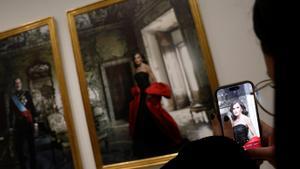 Una mujer toma una fotografía de primer plano durante una presentación ante los medios de los retratos del rey Felipe y la reina Letizia de España realizados por la fotógrafa estadounidense Annie Leibovitz como parte de la exposición La tirania de Cronos, en el Banco de España en Madrid, España, el 25 de noviembre. 2024
