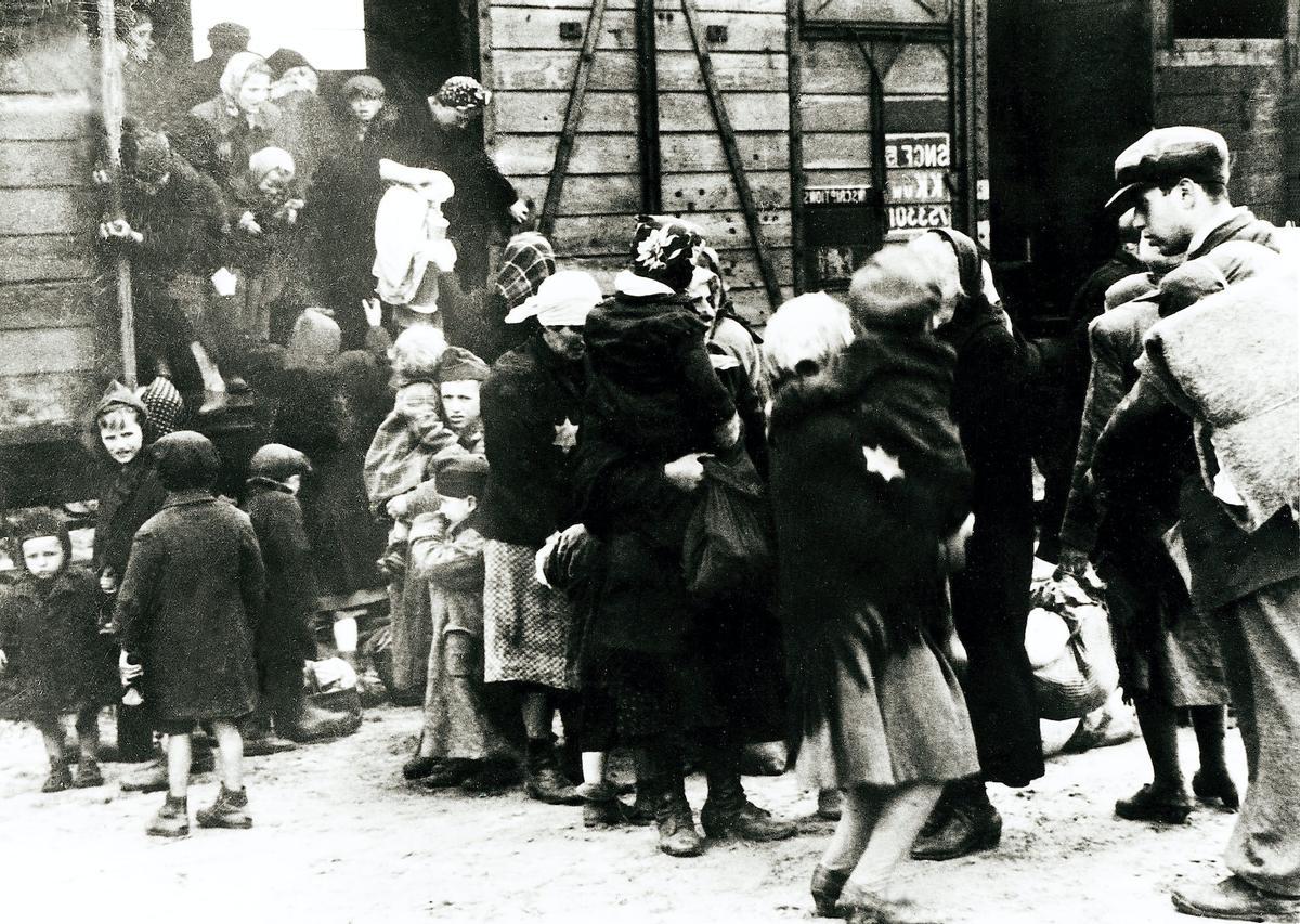 Mujeres y niños prisioneros descienden de un tren llegando a Auschwitz-Birkenau.