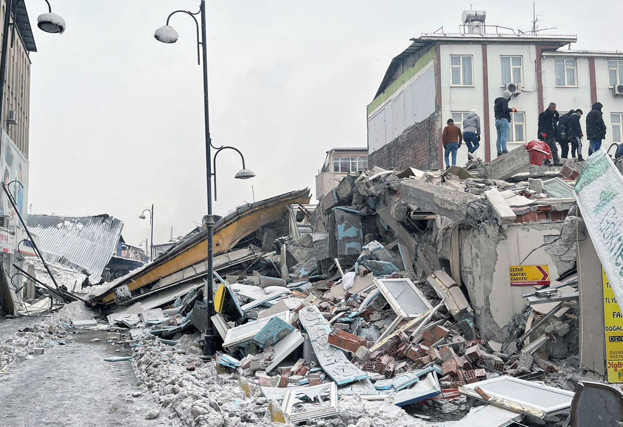 Un grupo de personas comprueba los daños materiales sufridos por un edificio en Turquía tras el terremoto en Kahramanmaras, cerca de la frontera con Siria