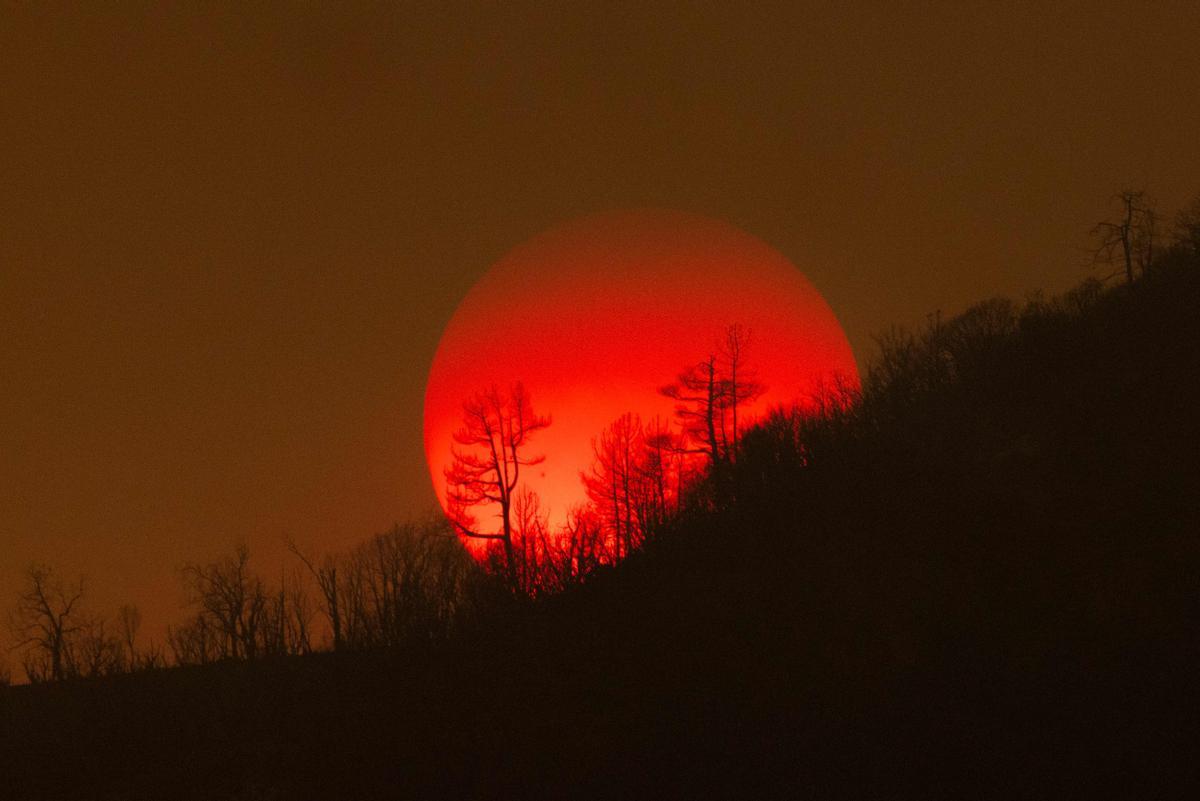 El sol se pone tras un cielo lleno de humo a causa del espectacular incendio conocido como Oak fire, declarado en los bosques cerca de Mariposa, California, el 24 de julio del 2022.