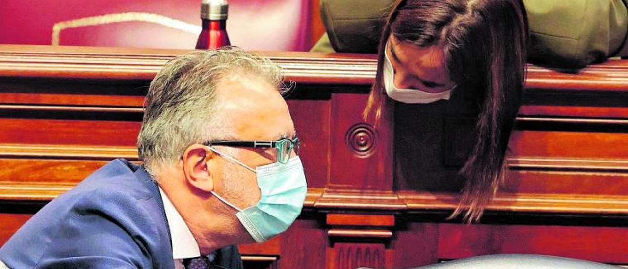 El presidente Ángel Víctor Torres en su escaño del Parlamento habla con la presidenta del grupo parlamentario socialista, Nira Fierro.