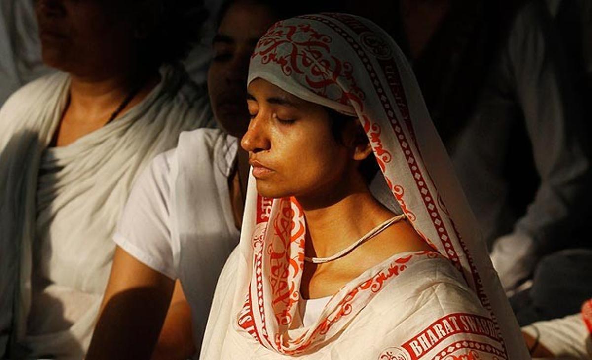 Una devota del popular guru iogui Baba Ramdev medita aquest dilluns durant una sessió al seu ’ashram’ de Haridwar (nord de l’Índia). El guru manté una vaga de fam i lidera una protesta de milers de persones contra la corrupció del país.